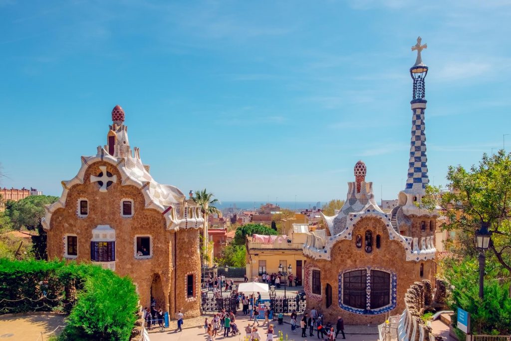 Edificios coloridos y caprichosos en el Parc Güell, diseñados por Antoni Gaudí en Barcelona, España, que muestran su distintivo estilo arquitectónico.